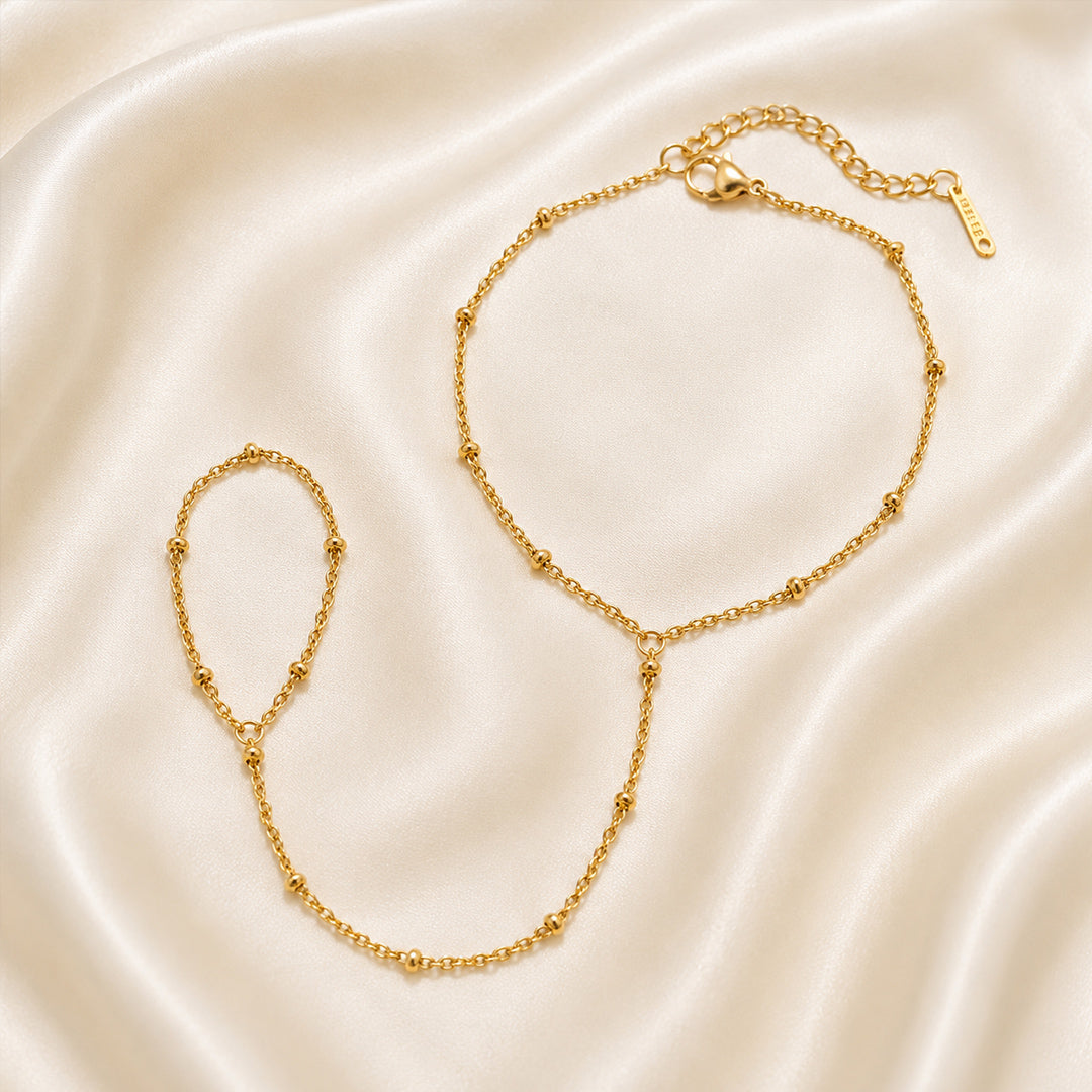 Gold handchain on a beige satin background