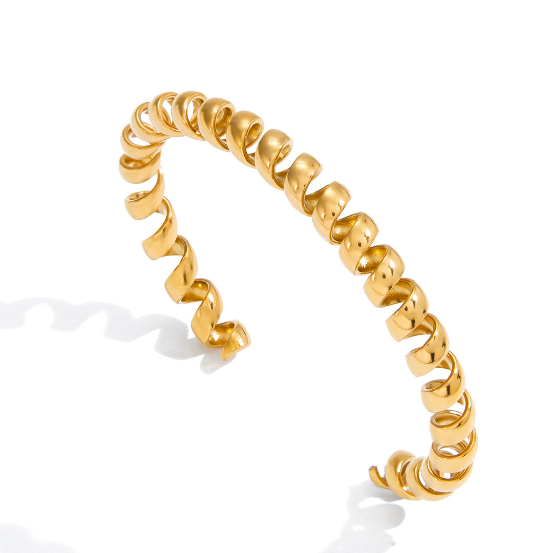Gold spiral cuff bracelet with sculptural open wrapped design in polished stainless steel