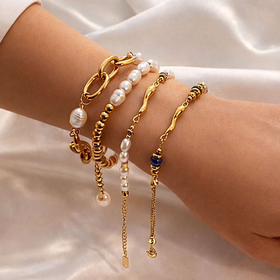 The Signature Pearl and Gold bracelet set on wrist, four-piece stack with pearl-effect beads and gold links