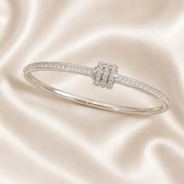 Silver bracelet with diamond accents on a satin background