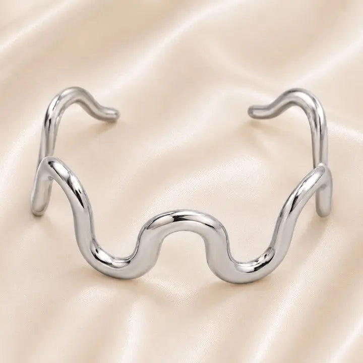 Celeste Sculptural Wave Cuff in polished Stainless Steel with organic flowing silhouette.