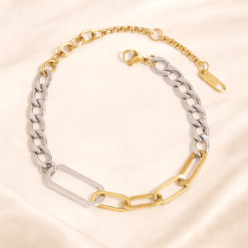 Two-tone link bracelet with silver-tone curb links and gold-tone elongated links on ivory background