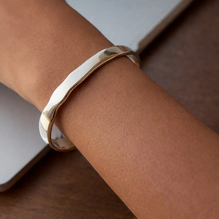 Silver-tone sculpted wave cuff bangle on wrist