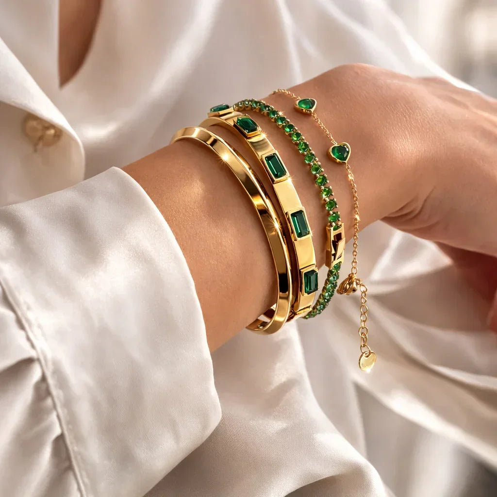 Emerald green bracelet set stacked on wrist, four-piece PVD gold-plated stack with emerald accents