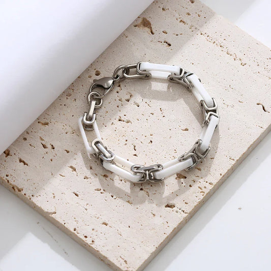 White ceramic and stainless steel chain bracelet product view on tabletop