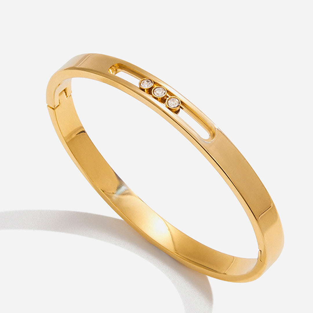Gold bracelet with embedded diamonds on a white background
