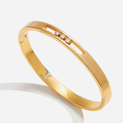 Gold bracelet with embedded diamonds on a white background