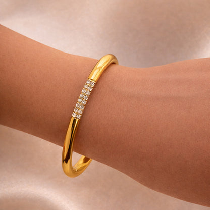 Gold cuff bracelet with pavé crystal detail on a sun-kissed wrist, luxury minimalist jewelry style