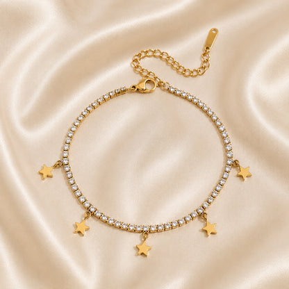 Gold bracelet with star charms on a satin background