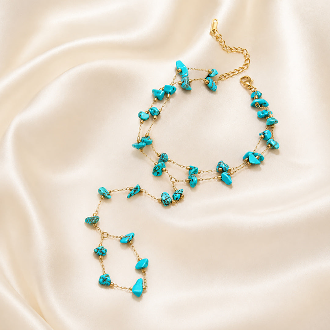 Gold handchain adorned with turquoise stones.