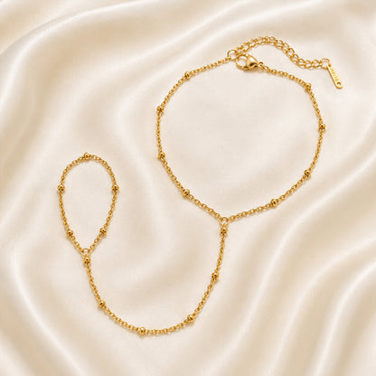 Gold handchain on a beige satin background