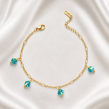 Azure Anklet in 18K PVD gold plating with four blue faceted crystal charms.
