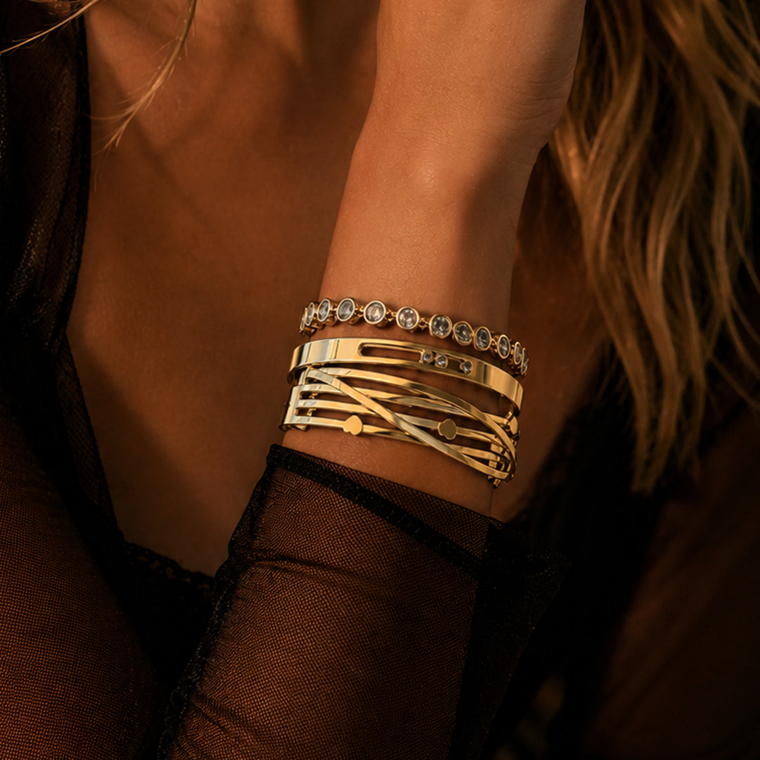 Amour Signature Stack featuring a gold heart cuff with bezel-set crystals paired with a delicate crystal tennis bracelet.