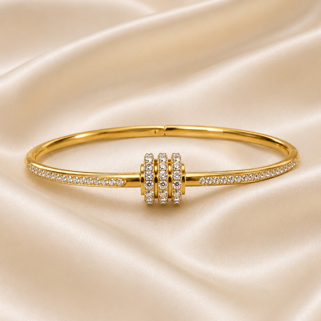 Gold bracelet with diamond accents on a satin background