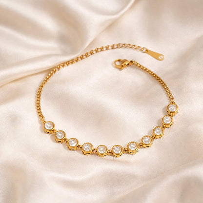 Gold-plated bezel-set zircon bracelet on ivory satin background