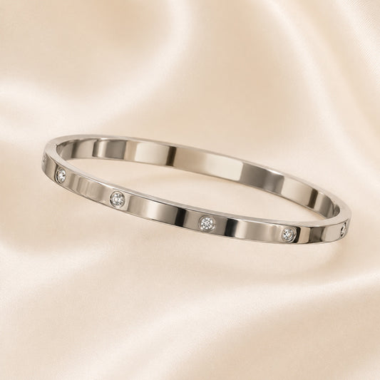 Silver bracelet with small diamonds on a beige background