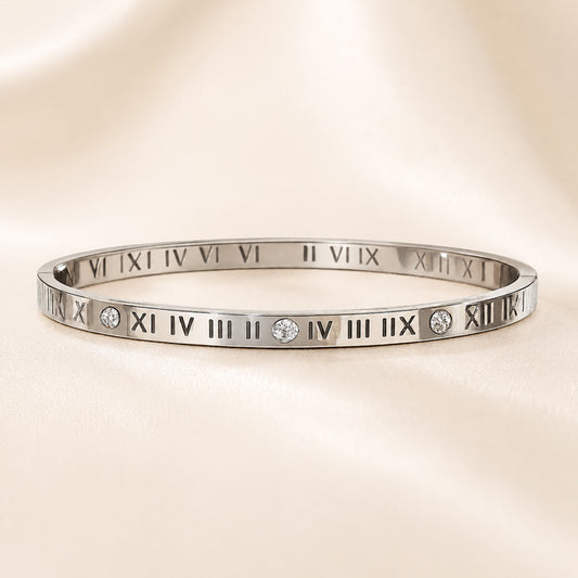 Silver bracelet with Roman numeral design on a beige background