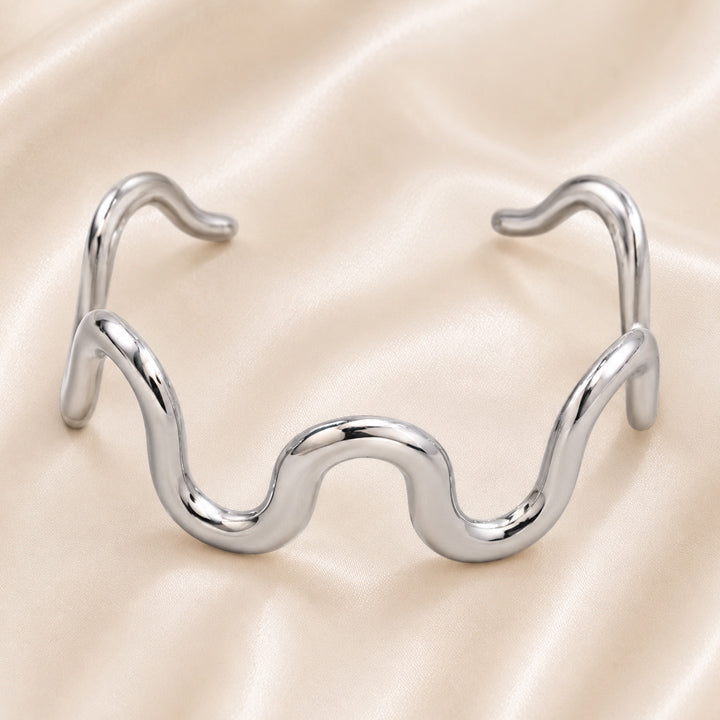 Celeste Sculptural Wave Cuff in polished Stainless Steel with organic flowing silhouette.