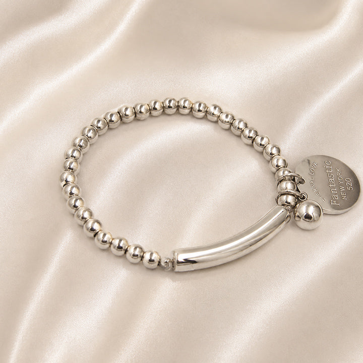 Luxury silver sphere charm bracelet with polished bead design and sculptural curved centerpiece.