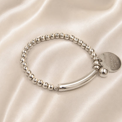 Luxury silver sphere charm bracelet with polished bead design and sculptural curved centerpiece.