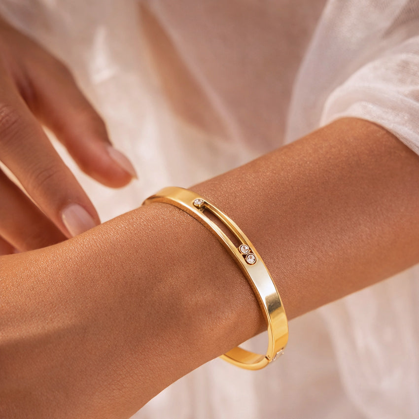 Gold bangle with trio zircon stones on wrist, part of Zircon Duo Radiance set