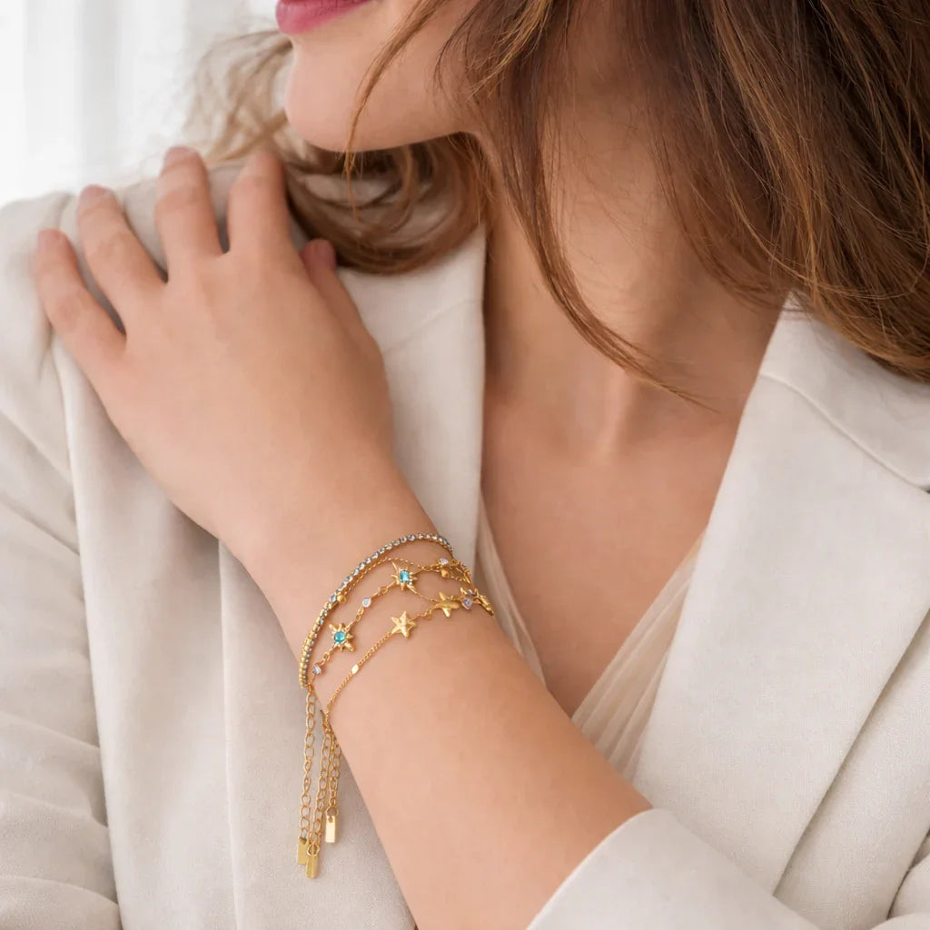 Turquoise Trio gold bracelet set on wrist, three-piece layered chain stack with turquoise zircon accents