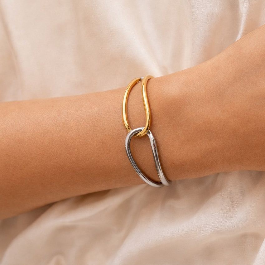 Double tone sculpted cuff bracelet on wrist, silver and gold interwoven design