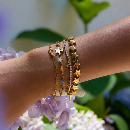 Triple star gold-plated double-chain bracelet on wrist, adjustable chain design
