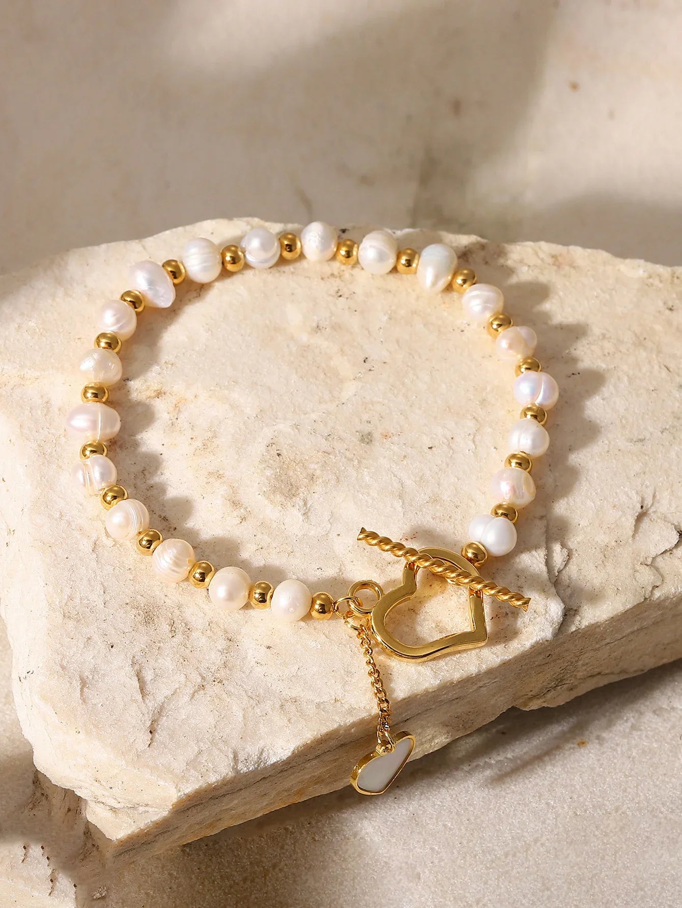 Faux pearl toggle bracelet flat lay with heart clasp, pearl-effect beads and gold finish