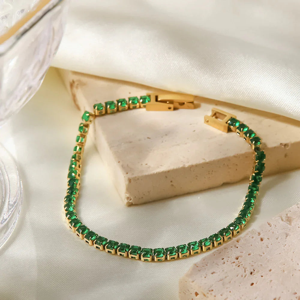 Emerald green tennis bracelet flat lay, PVD gold-plated setting with continuous stone line