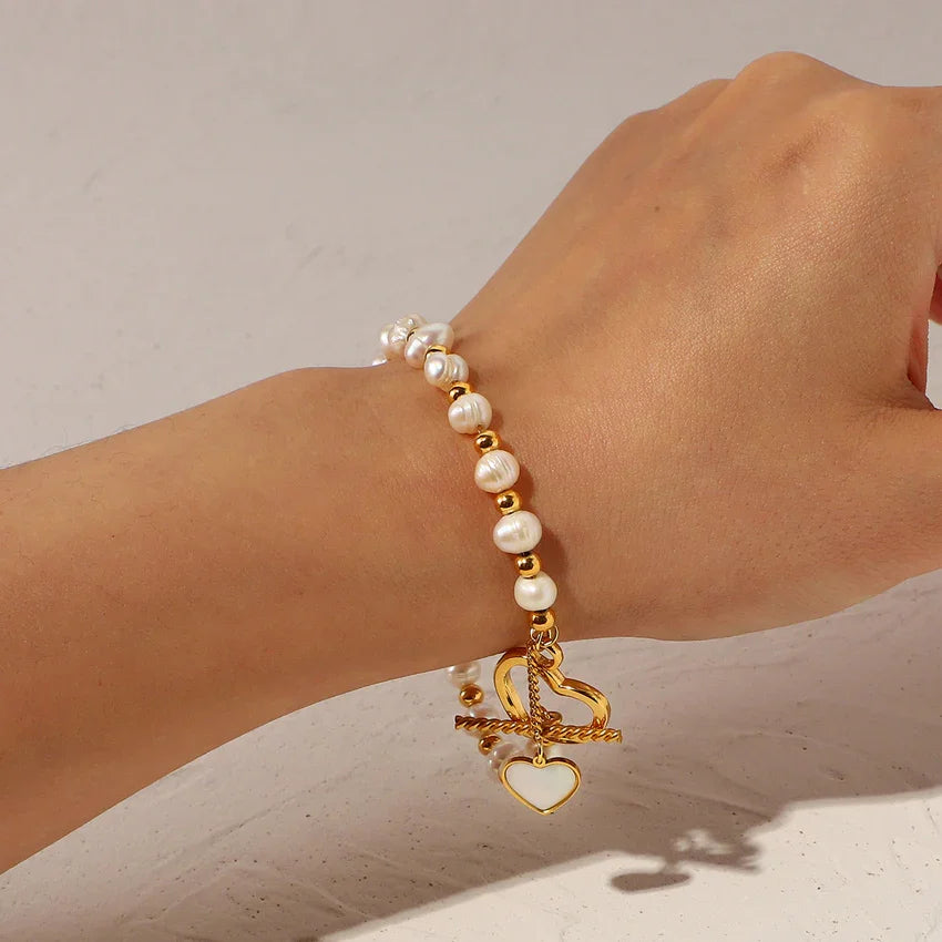 Faux pearl bracelet on wrist with sculpted heart toggle, PVD gold plating