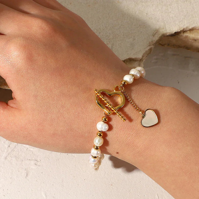 Faux pearl bracelet with heart toggle clasp in PVD gold plating on wrist