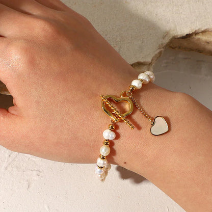 Faux pearl bracelet with heart toggle clasp in PVD gold plating on wrist