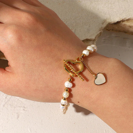 Faux pearl bracelet with heart toggle clasp in PVD gold plating on wrist