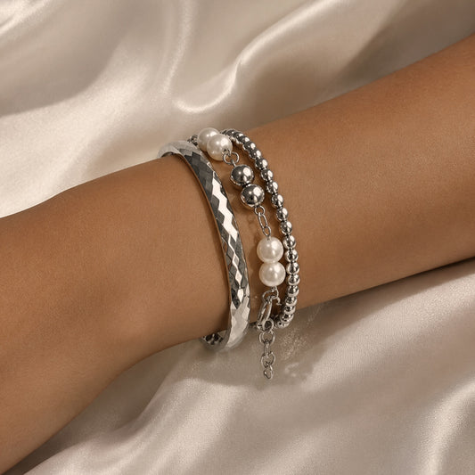 Éclat Perlé Stainless Steel bracelet stack featuring faceted bangle with pearl and polished bead layered bracelets worn on wrist