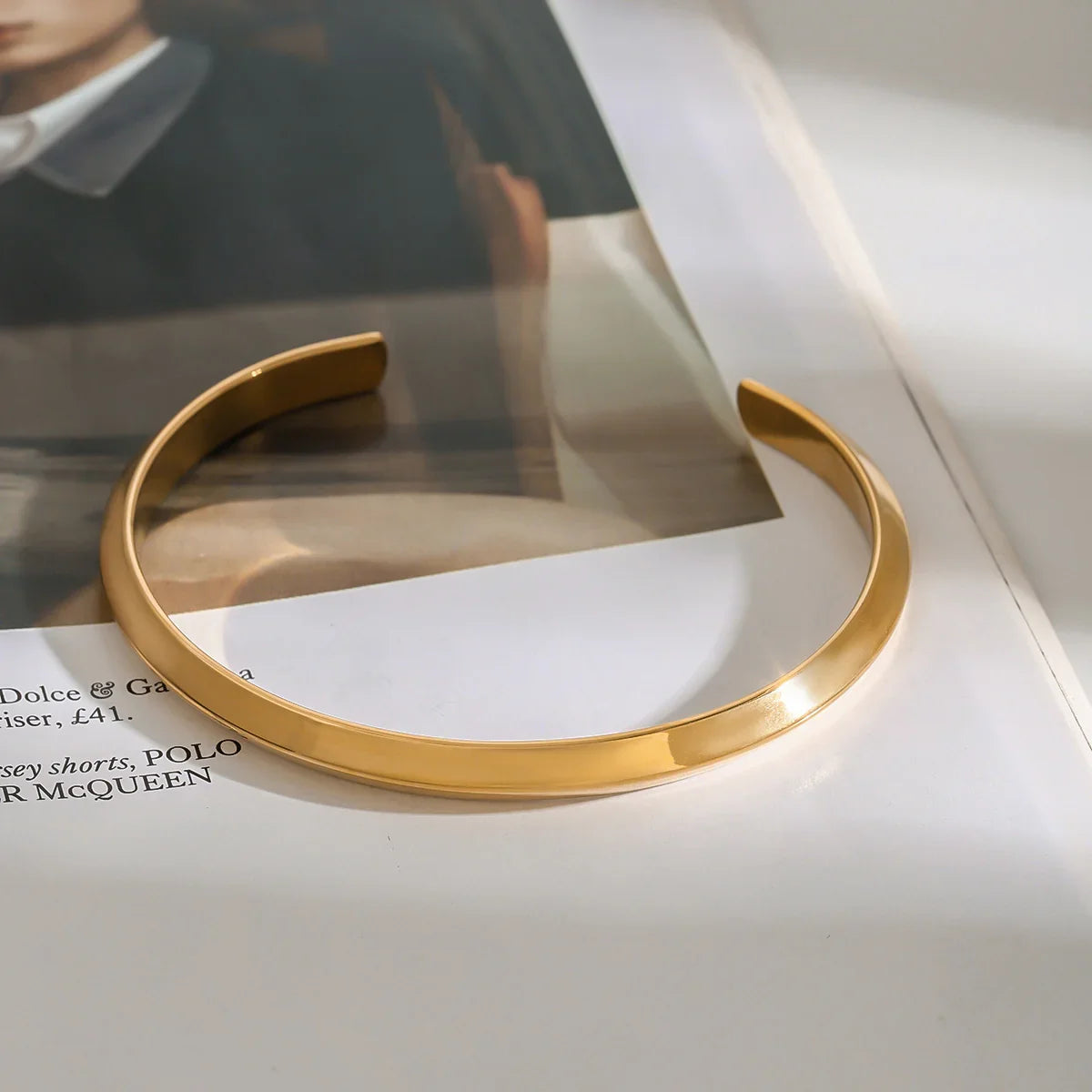 Gold-plated open cuff close-up showing smooth curvature and polished edge