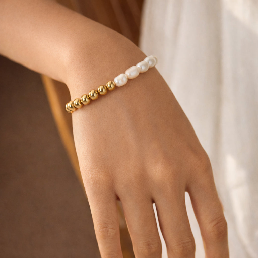 Pearl and gold sphere bracelet on wrist, stretch-fit design