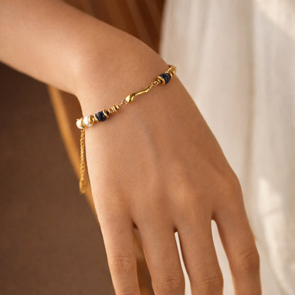 Lapis Blue Accent gold bracelet on wrist with deep blue accents, adjustable chain
