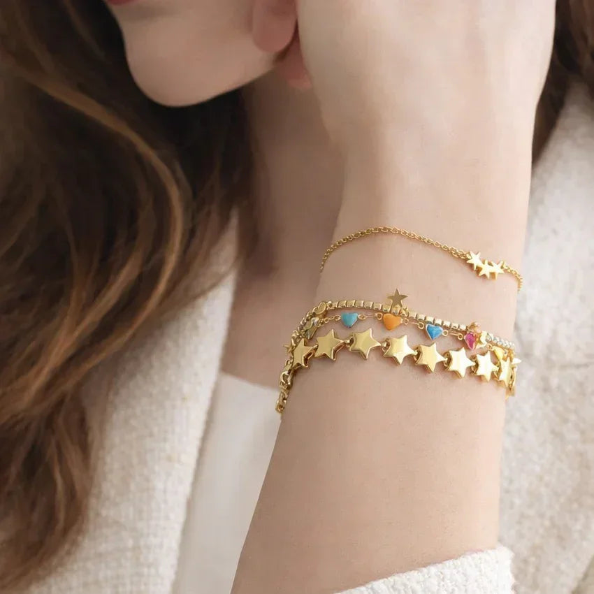 Pavé crystal line star accent bracelet on wrist, gold plating over stainless steel