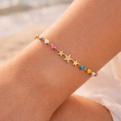 Stella multicolor star bracelet on wrist, gold-plated star motifs with enamel accents