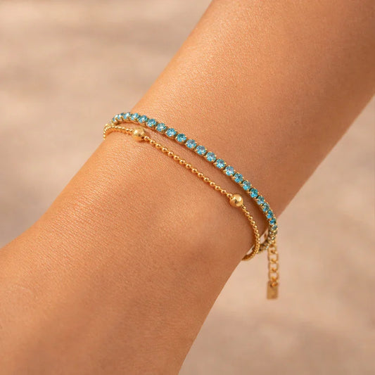 Azure Lumière Duo tennis bracelet on wrist, double-layer gold-plated design with turquoise zircon stones